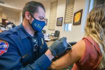 North Las Vegas Fire Department fire equipment specialist Victor Mancilla administrates a COVID ...