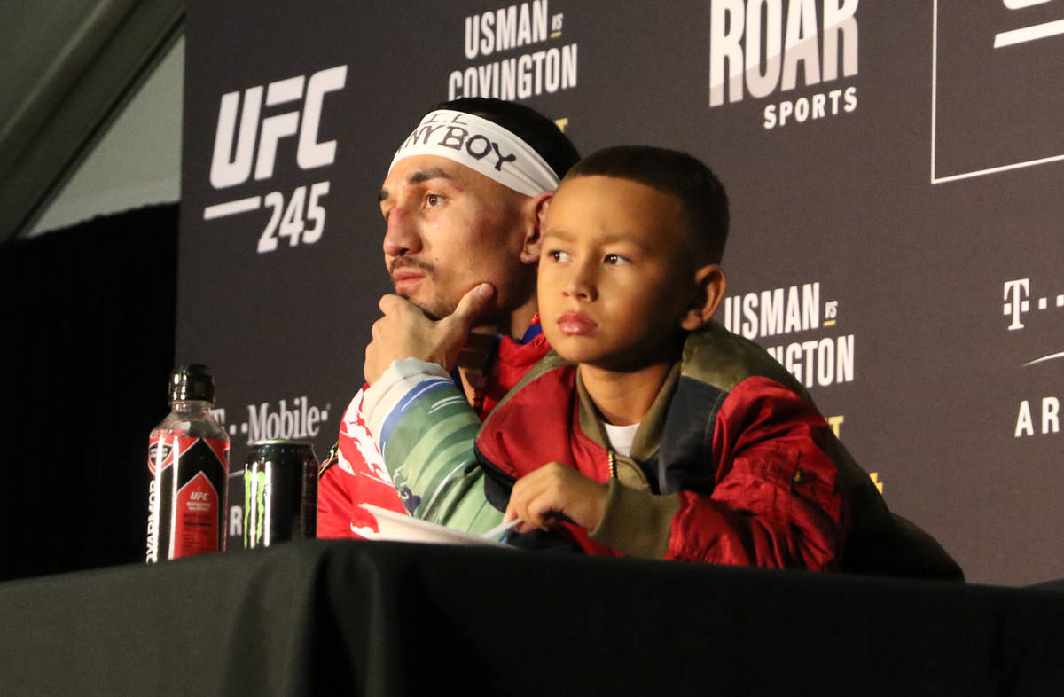UFC featherweight Max Holloway and his son, Rush, listen to a question being asked during the U ...