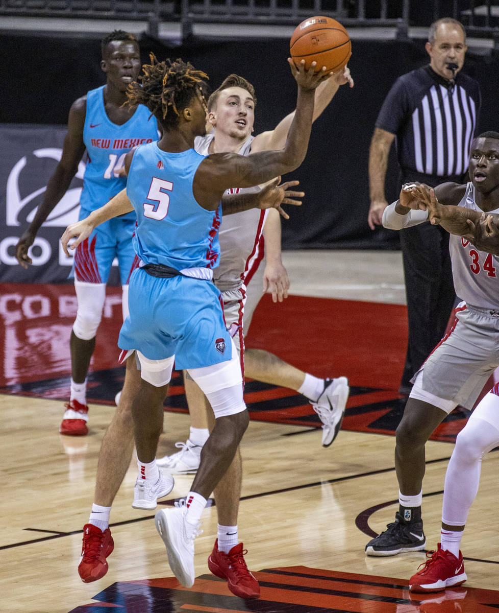 New Mexico Lobos forward Rod Brown (5) has a shot rejected by UNLV Rebels forward Moses Wood (1 ...