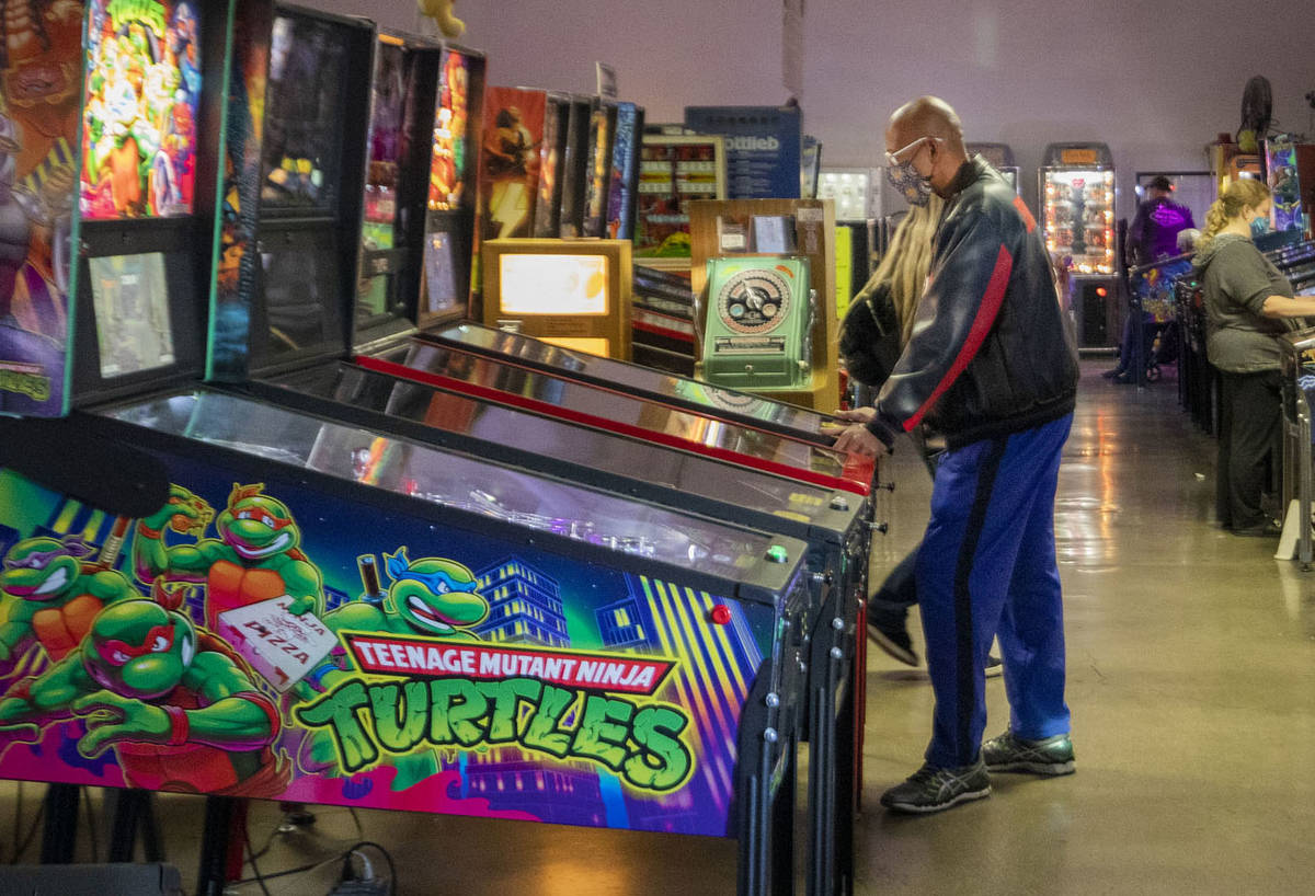 Individuals play pinball during the Pinball Hall of Fame launch of a weekly food truck gatherin ...