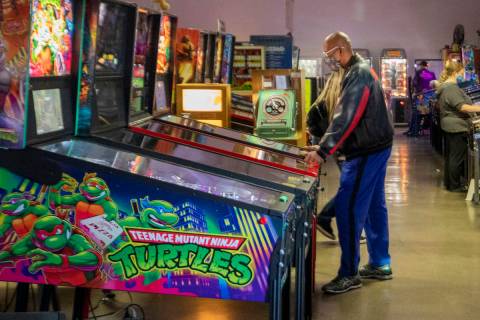 Individuals play pinball during the Pinball Hall of Fame launch of a weekly food truck gatherin ...