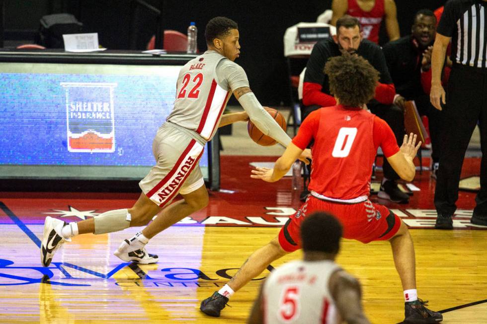 UNLV Rebels guard Nick Blake (22) dribbles past New Mexico Lobos guard Isaiah Marin (0) during ...