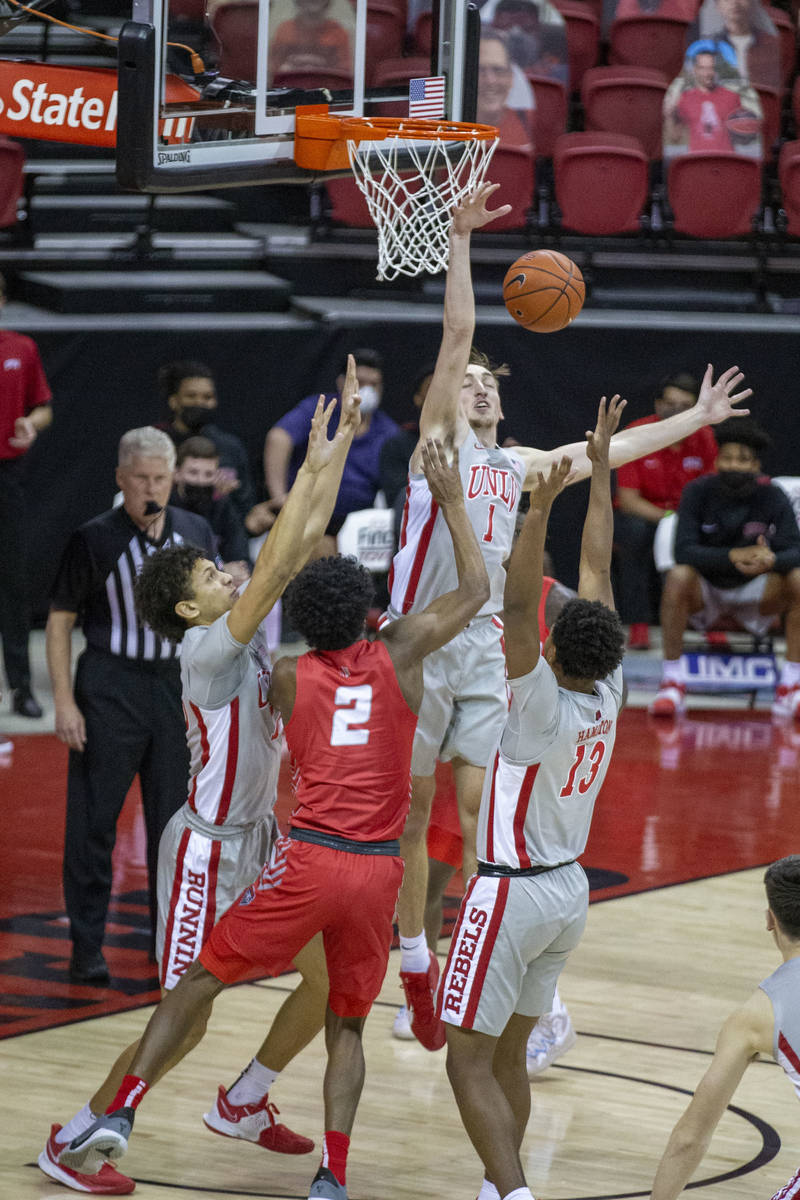 UNLV Rebels forward Moses Wood (1) blocks a shot from New Mexico Lobos guard Saquan Singleton ( ...