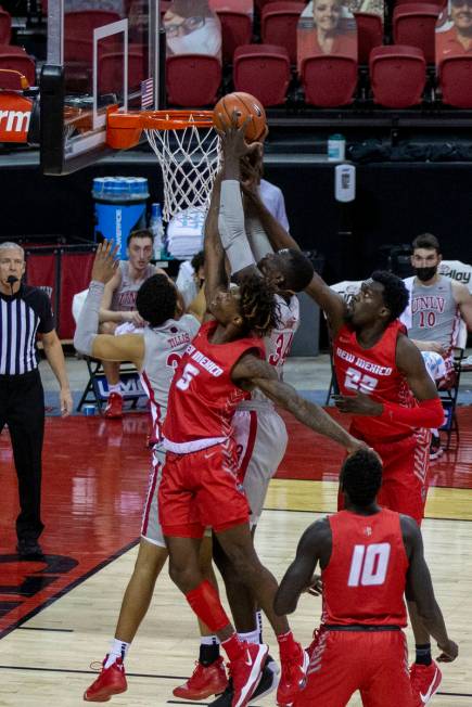 New Mexico Lobos forward Valdir Manuel (22) and forward Rod Brown (5) fight for the basketball ...