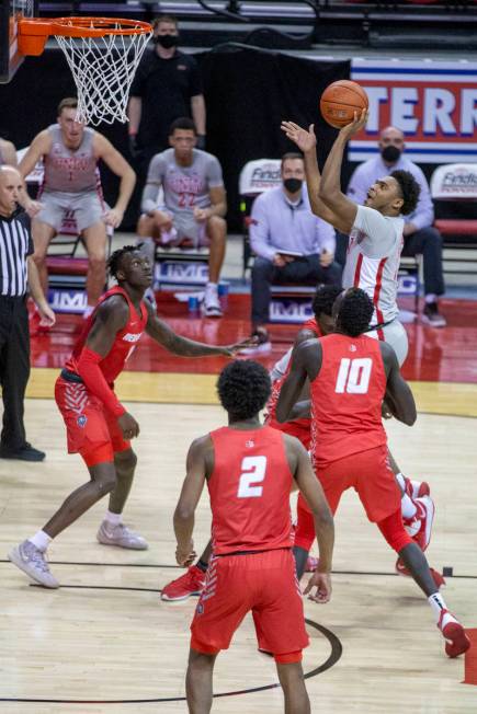 UNLV Rebels guard Bryce Hamilton (13) makes a basket over New Mexico Lobos guard Saquan Singlet ...