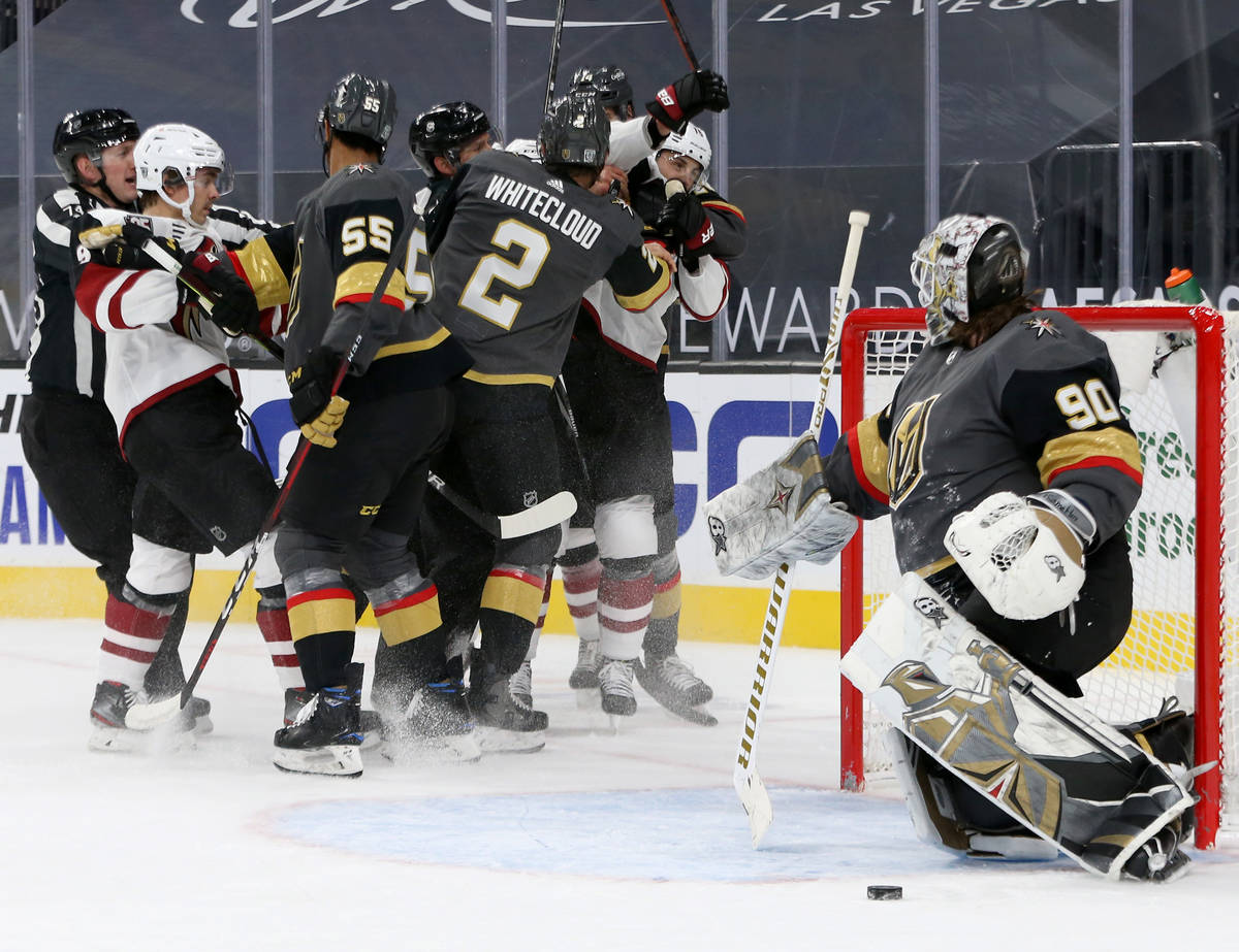 Golden Knights' defenseman Zack Whitecloud (2) throws a punch at Arizona Coyotes left wing John ...