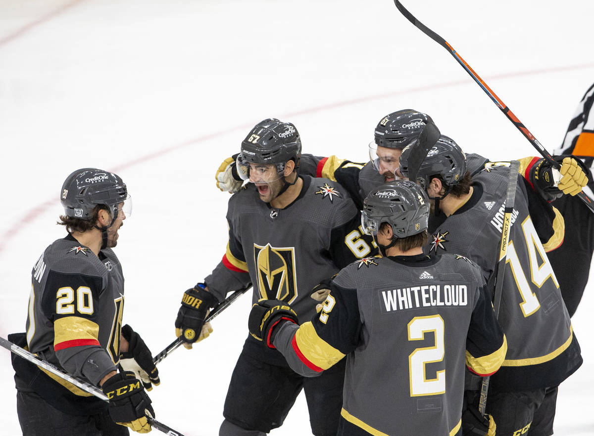 Golden Knights' center Chandler Stephenson (20) celebrates with team members after scoring his ...