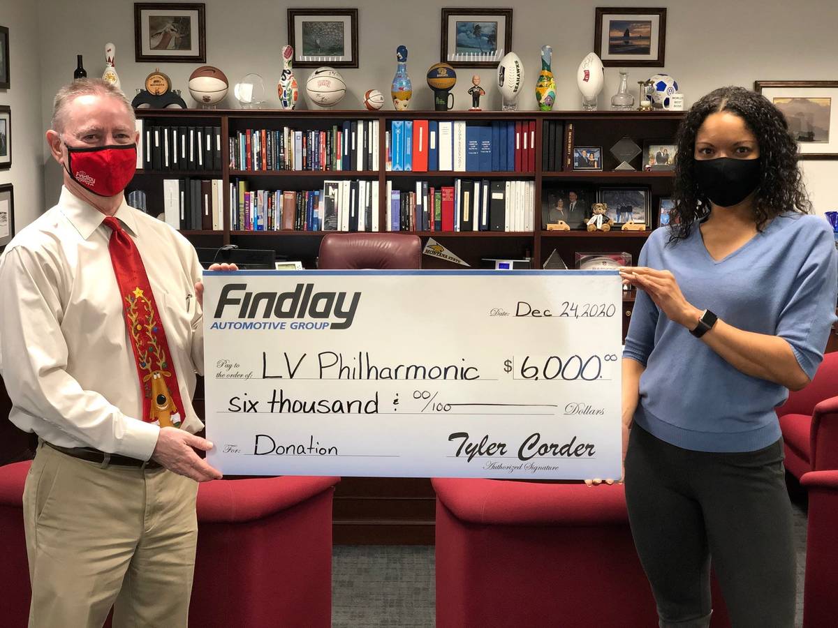 Findlay Automotive Group CFO Tyler Corder presents a check to Findlay human resources manager a ...