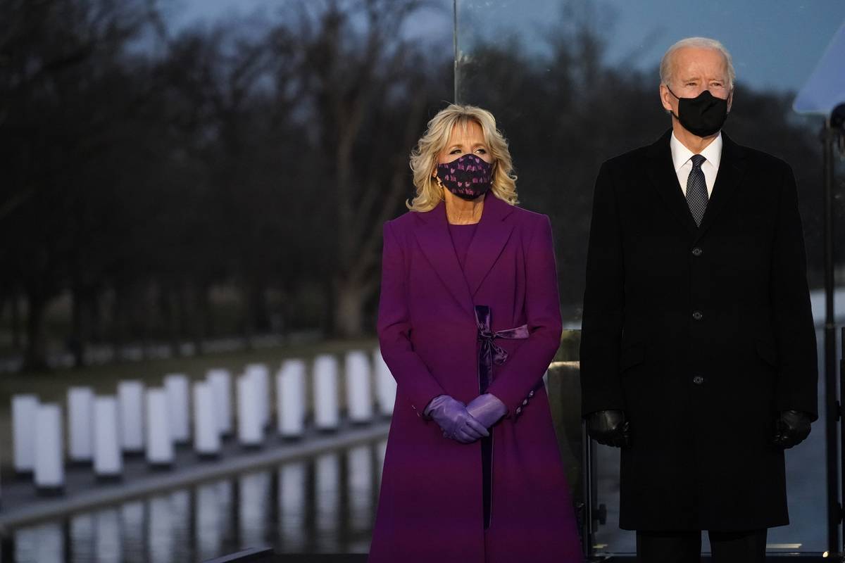 President-elect Joe Biden and Jill listen during a COVID-19 memorial, with lights placed around ...