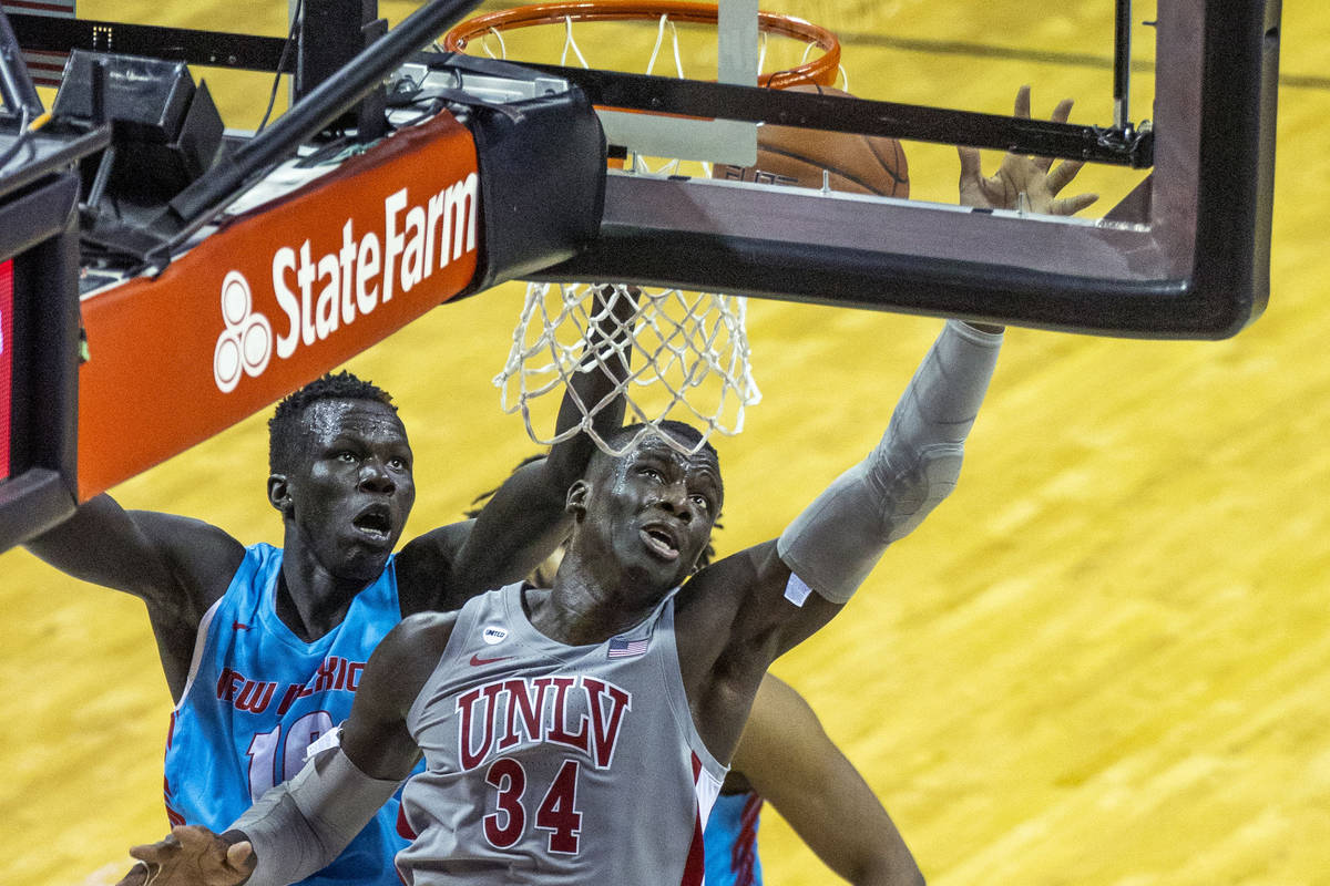 UNLV Rebels forward Cheikh Mbacke Diong (34) battles about the glass with New Mexico Lobos guar ...