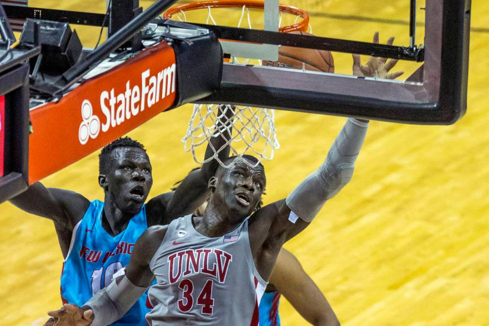 UNLV Rebels forward Cheikh Mbacke Diong (34) battles about the glass with New Mexico Lobos guar ...