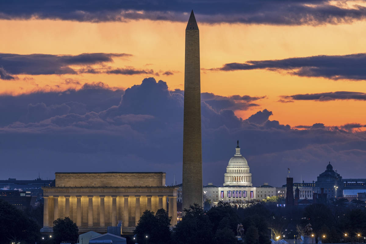 Dawn breaks behind the Lincoln Memorial, Washington Monument, and the U.S. Capitol on Inaugurat ...
