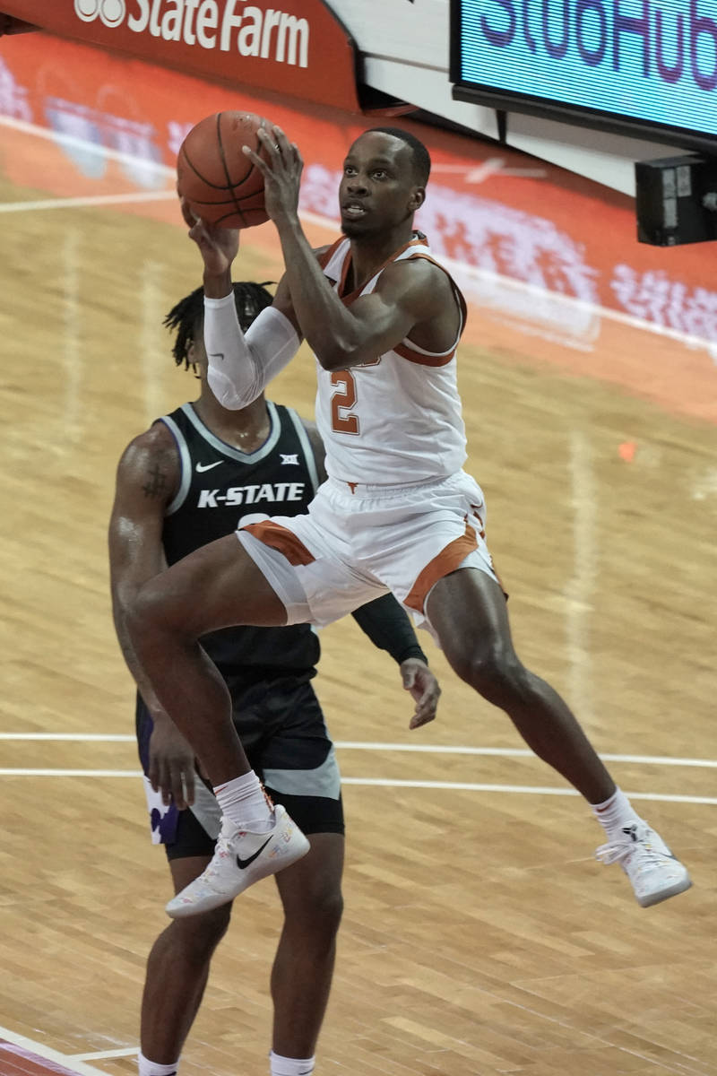 Texas' Matt Coleman III, right, drives past Kansas State's Selton Miguel during the first half ...