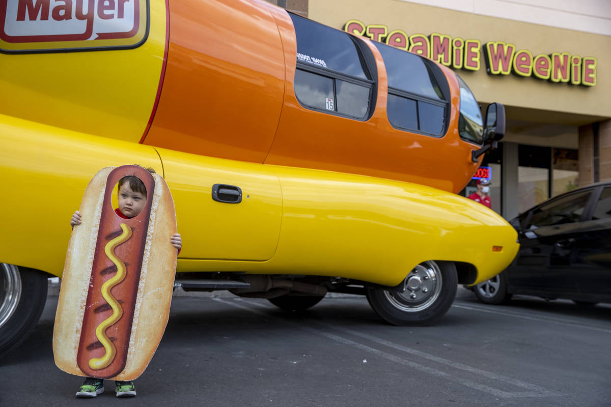 Brenden McCormack, 3, has his picture taken beside the Oscar Mayer Wienermobile parked outside ...