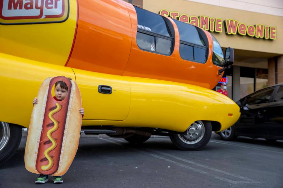 Brenden McCormack, 3, has his picture taken beside the Oscar Mayer Wienermobile parked outside ...