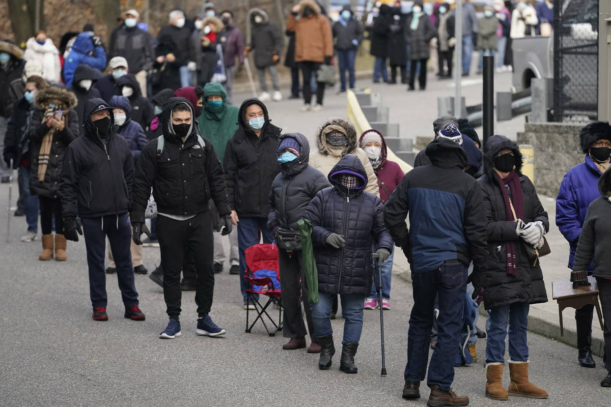 People wait in line for the COVID-19 vaccine in Paterson, N.J., Thursday, Jan. 21, 2021. The fi ...