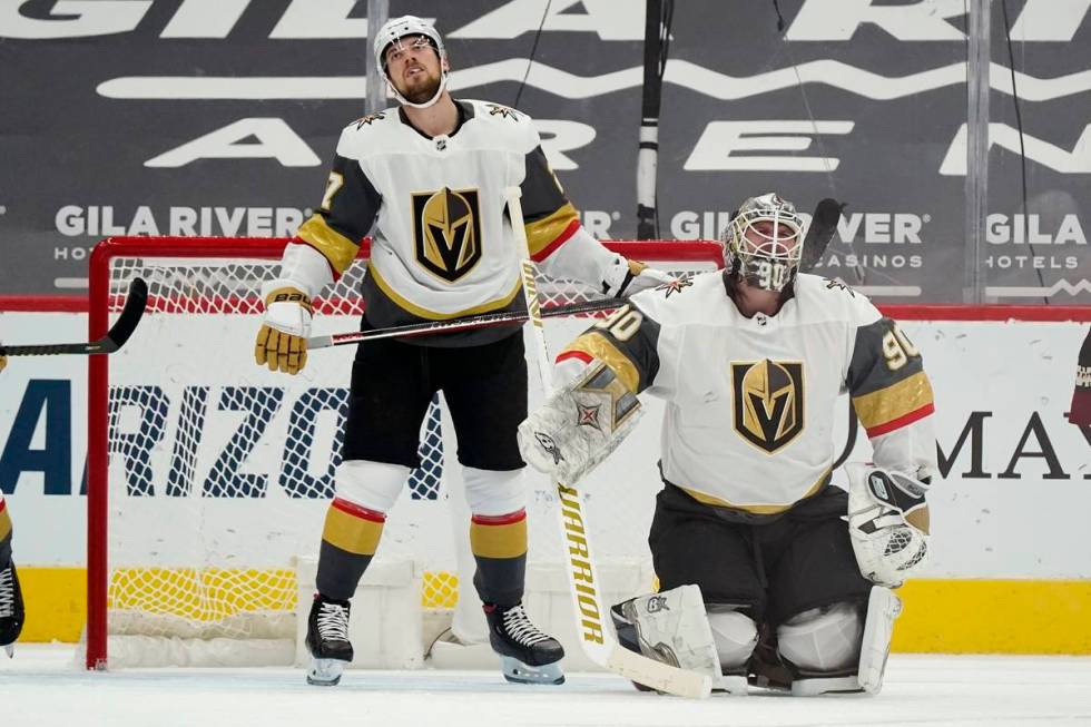 Vegas Golden Knights goaltender Robin Lehner (90) and defenseman Shea Theodore, left, pause on ...