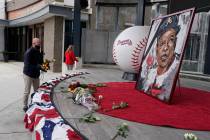 Atlanta Braves employees place flowers next to a portrait Atlanta Braves' Hank Aaron outside Tr ...