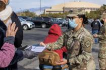 PFC Wendy Garcia passes out paperwork as people wait in line to enter the Cashman Center for CO ...