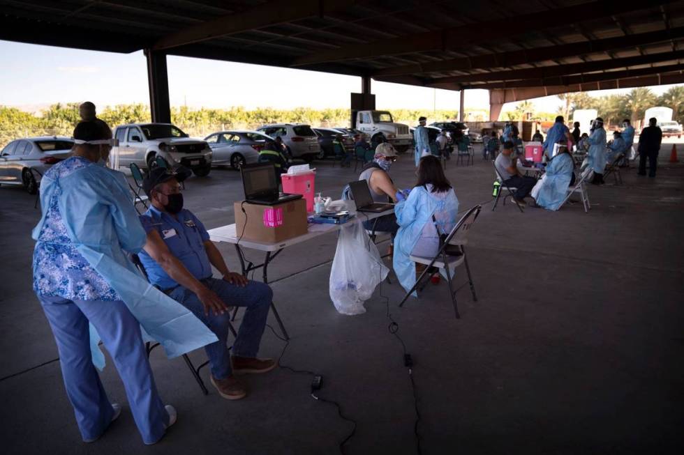 Farm workers receive the Pfizer-BioNTech COVID-19 vaccine at Tudor Ranch in Mecca, Calif., in J ...