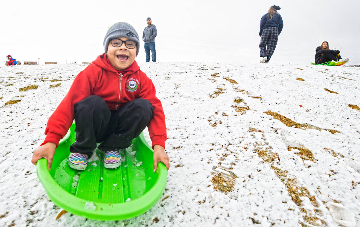 Gabriel Prieto, 8, sleds down a hill at Knickerbocker Park on Monday, Jan. 25, 2021, in Las Veg ...