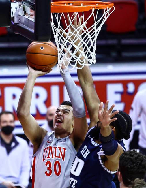 UNLV Rebels forward Devin Tillis (30) goes to the basket against Utah State Aggies forward Alph ...