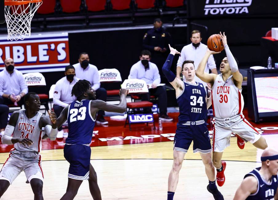 UNLV Rebels forward Devin Tillis (30) shoots over Utah State Aggies forward Justin Bean (34) du ...