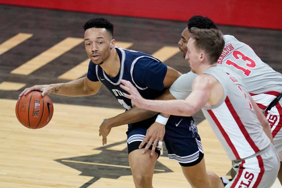 Utah State's Marco Anthony (44) drives around UNLV's Bryce Hamilton (13) and Moses Wood during ...