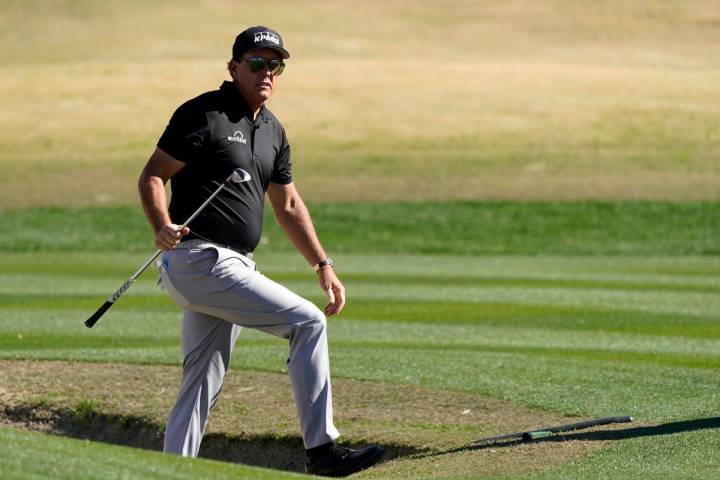 Phil Mickelson walks out from a bunker after hitting to the 17th green during the first round o ...