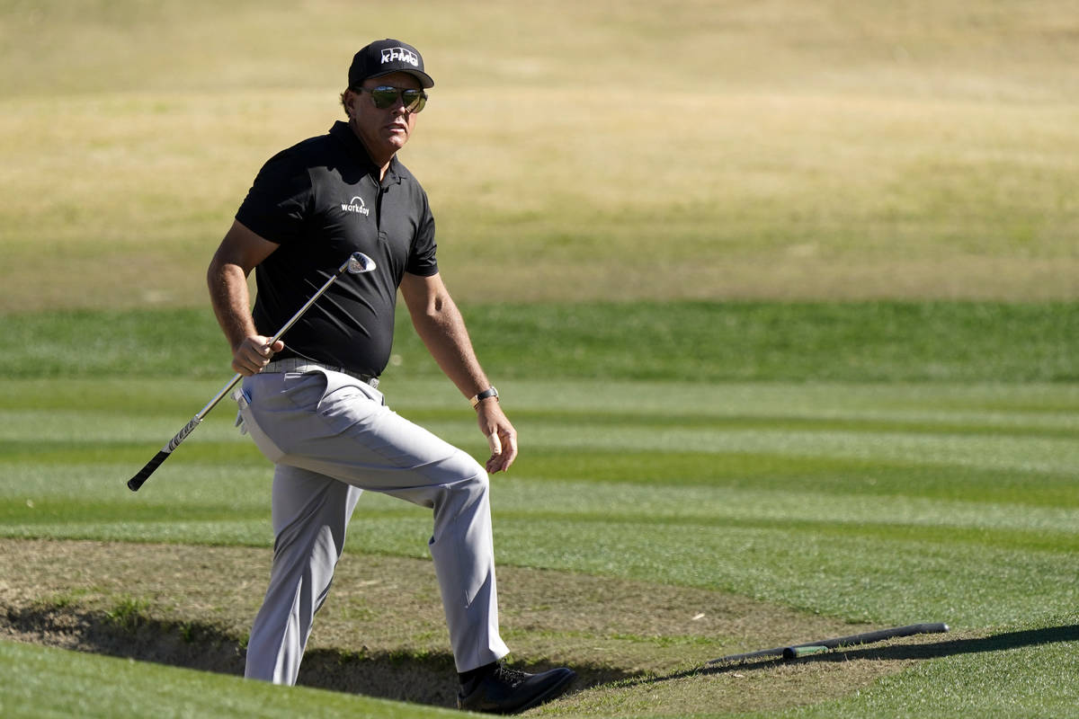 Phil Mickelson walks out from a bunker after hitting to the 17th green during the first round o ...