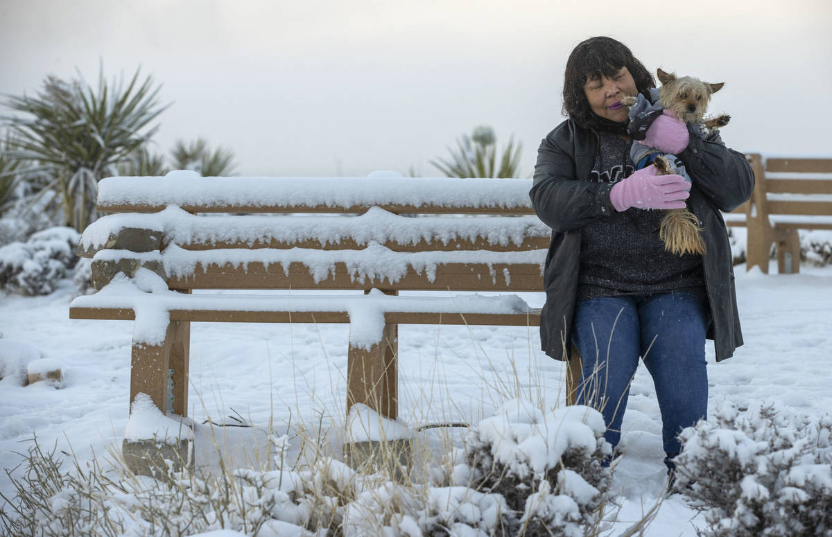 Charonn Williams sits with her dog Snickers up on the overlook as the clouds break on a snowy d ...