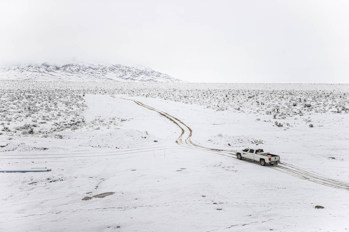 A truck makes its way through the snow at a construction sight in northwest Las Vegas on Tuesda ...