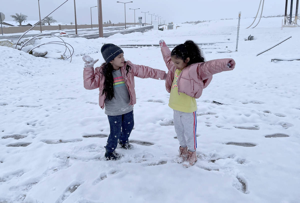 Kelly Sanchez, 7, left, and her sister Kyara, 5, play in freshly fallen snow at the intersectio ...