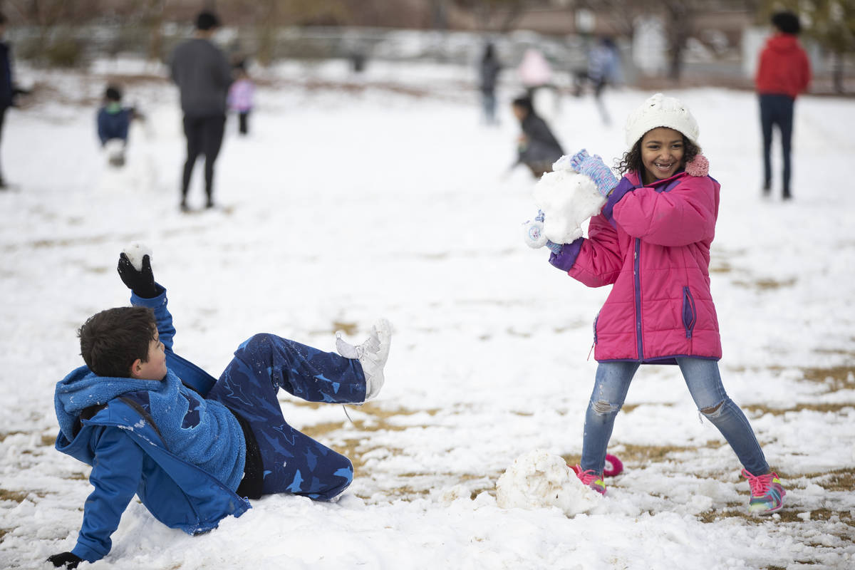 Cash' Mir Segovia, 7, gets ready to throw a snowball at her brother King, 7, at Huckleberry Par ...