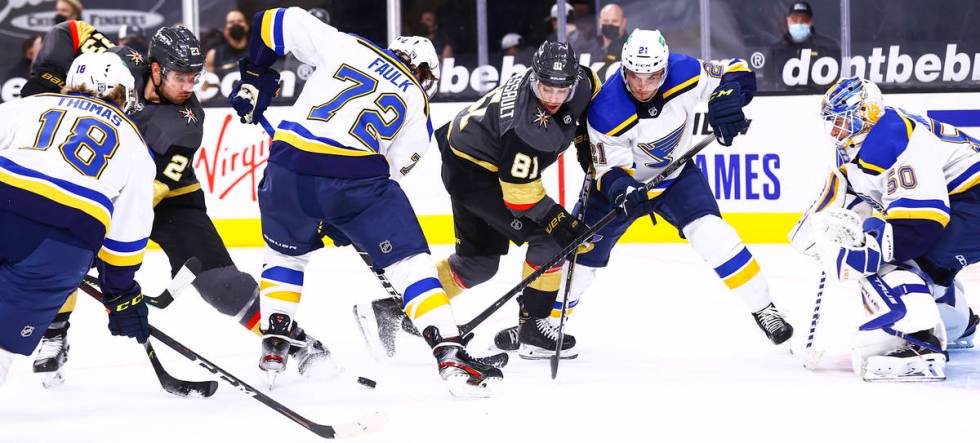 Golden Knights defenseman Alec Martinez (23) and center Jonathan Marchessault (81) fight for th ...