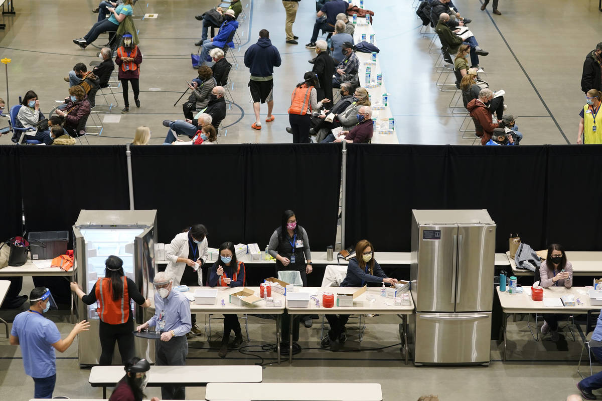 In a Jan. 24, 2021, file photo, people work near refrigerators used to store the Pfizer vaccine ...