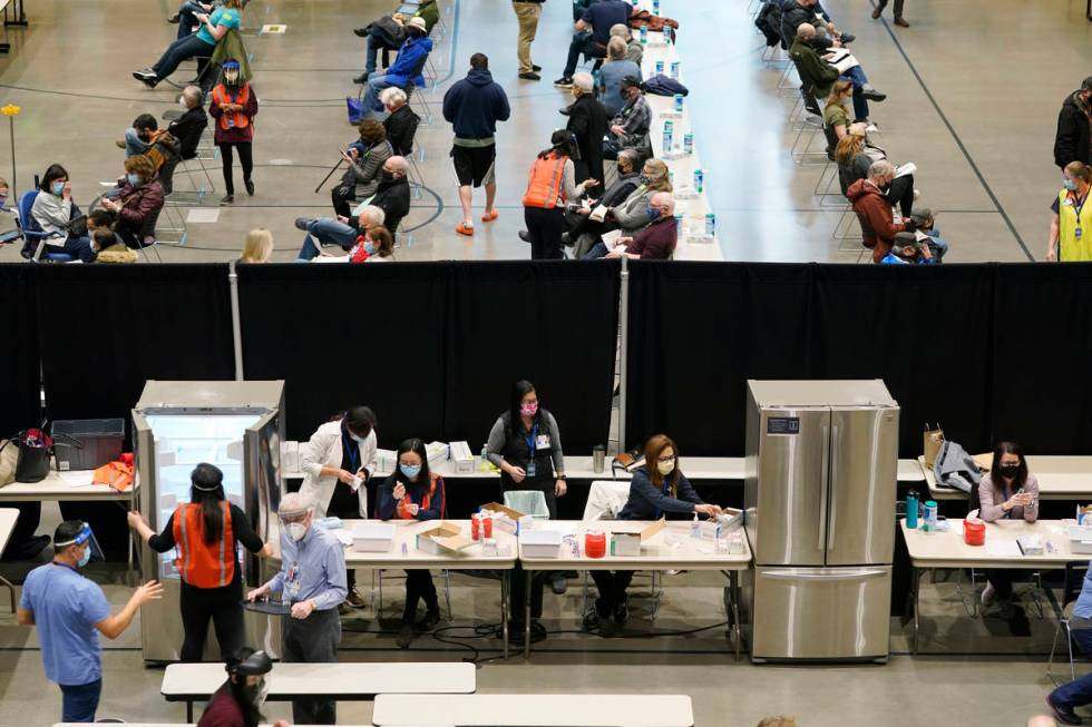 In a Jan. 24, 2021, file photo, people work near refrigerators used to store the Pfizer vaccine ...