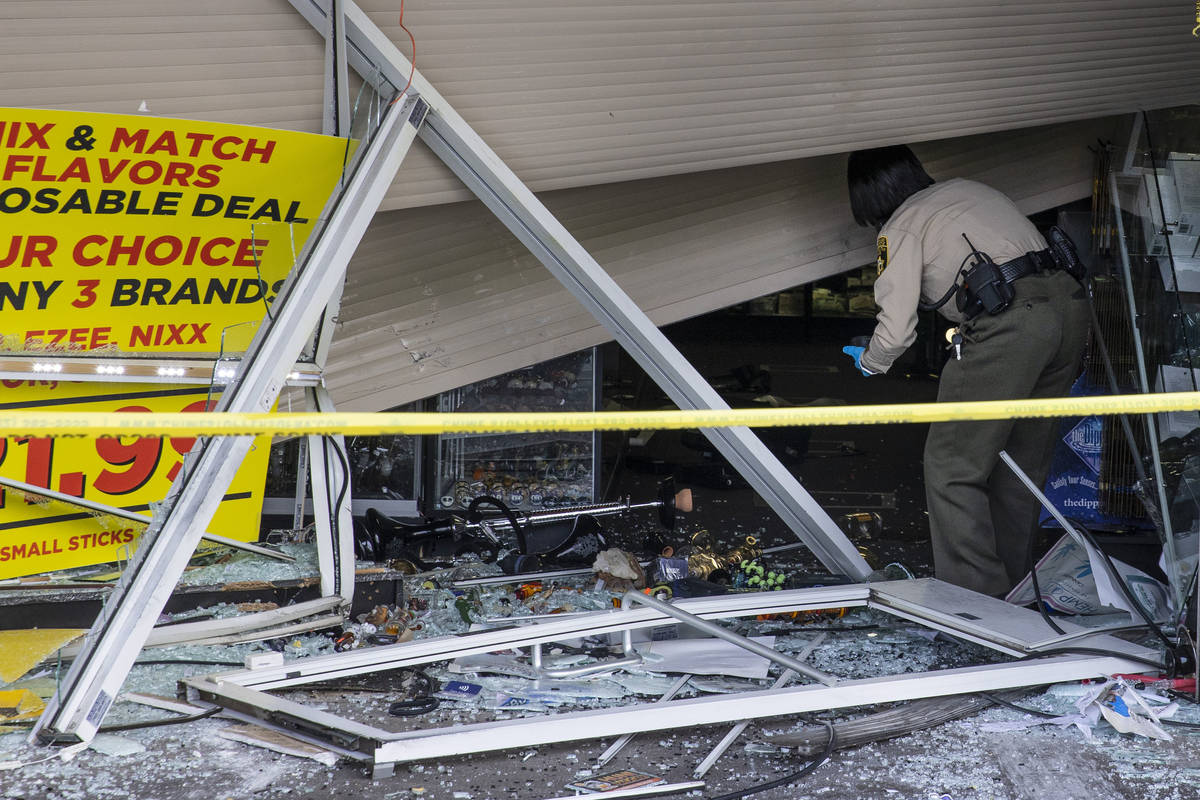 The Metropolitan Police Department investigates after a car crashed into a smoke shop as part o ...