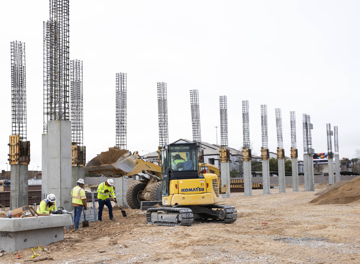 Construction workers flatten the ground at the construction site of Axiom, an office complex un ...