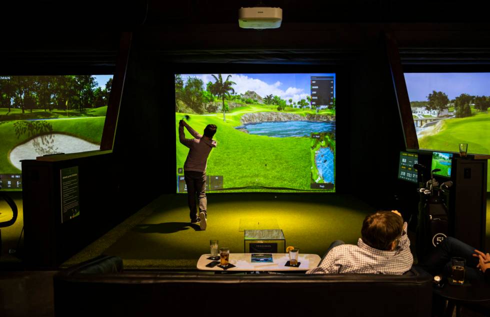 Gerry Montiel, of Henderson, takes a swing during a friends and family event at Five Iron Golf ...