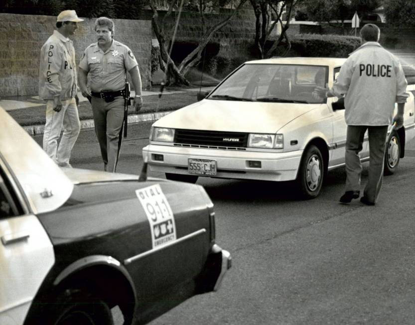 Las Vegas police Detective Michael Karstedt, far left, works with Officer Mike Hoppe and Detect ...