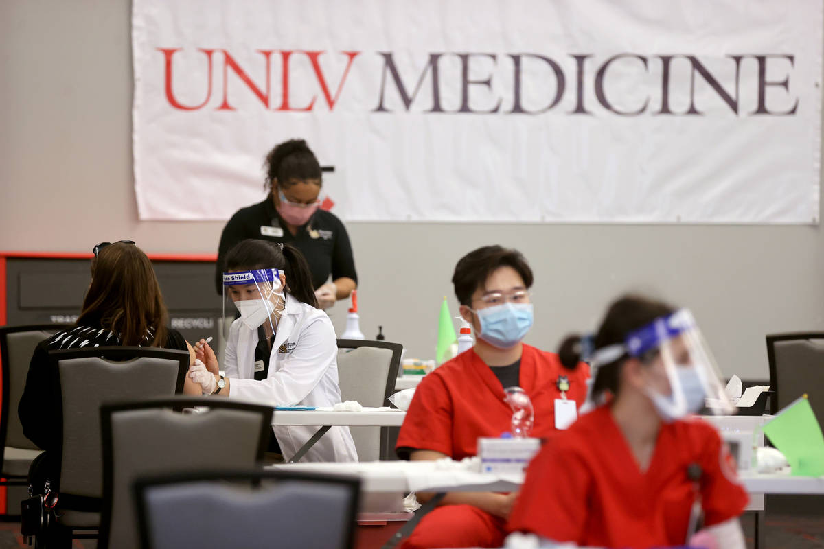 Angela Kong, left, a Nevada State College nursing student, gives a COVID-19 vaccine during a UN ...