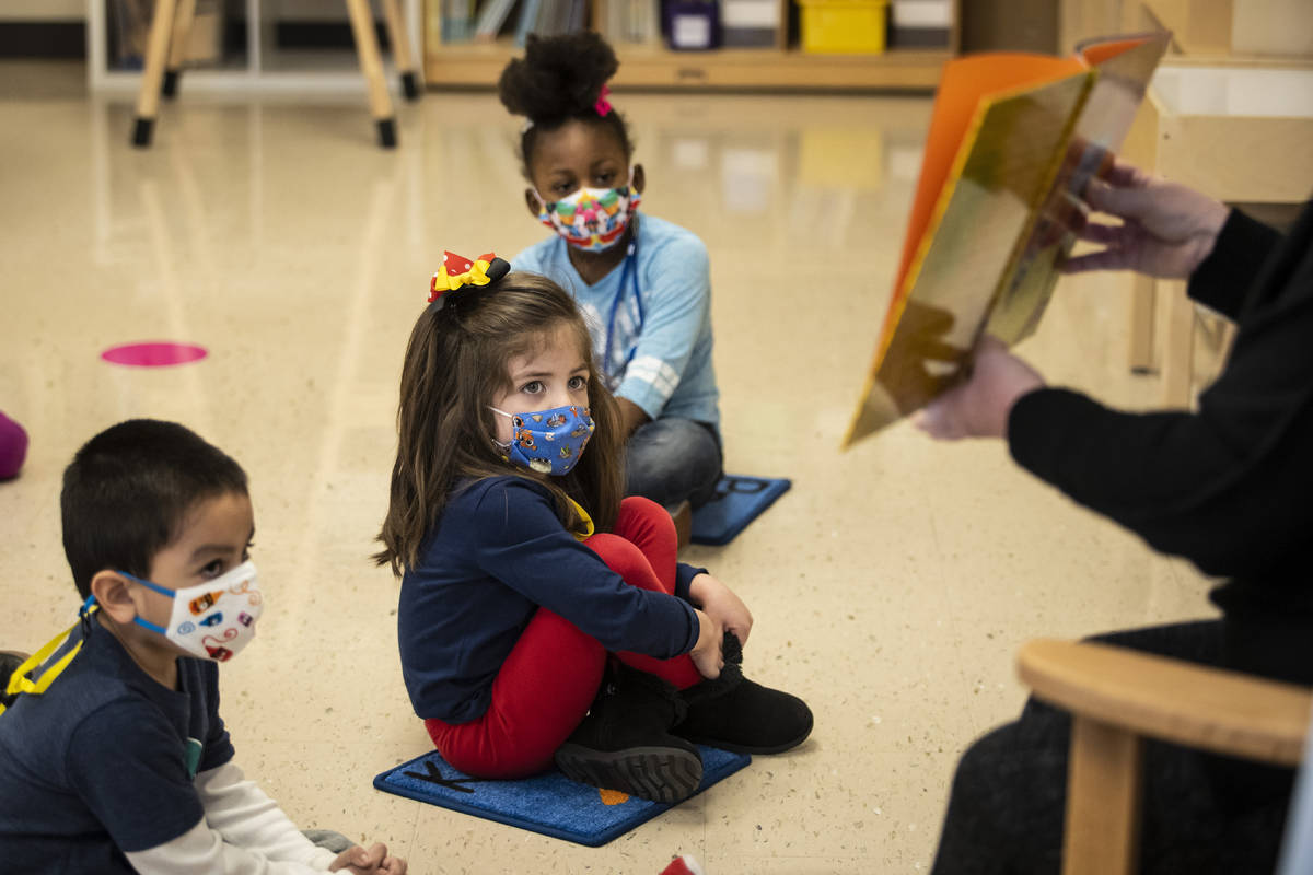 Pre-kindergarten students listen as their teacher reads a story at Dawes Elementary in Chicago, ...