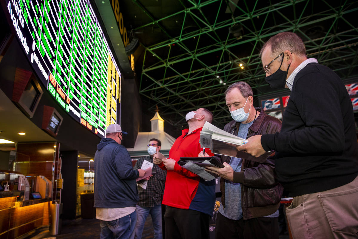 (From left) Bettors James, Jimmy and Logan Fields go over the numbers in line as the Westgate s ...