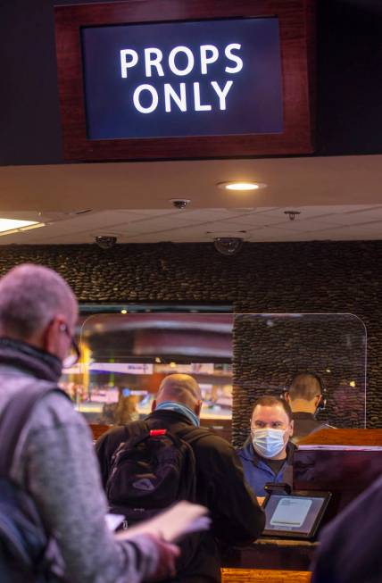 Mike Iannone, right, confers the bets placed by a bettor as the Westgate sportsbook posts hundr ...