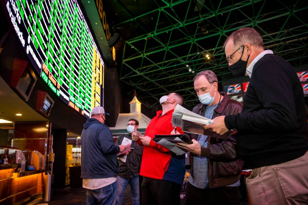 (From left) Bettors James, Jimmy and Logan Fields go over the numbers in line as the Westgate s ...
