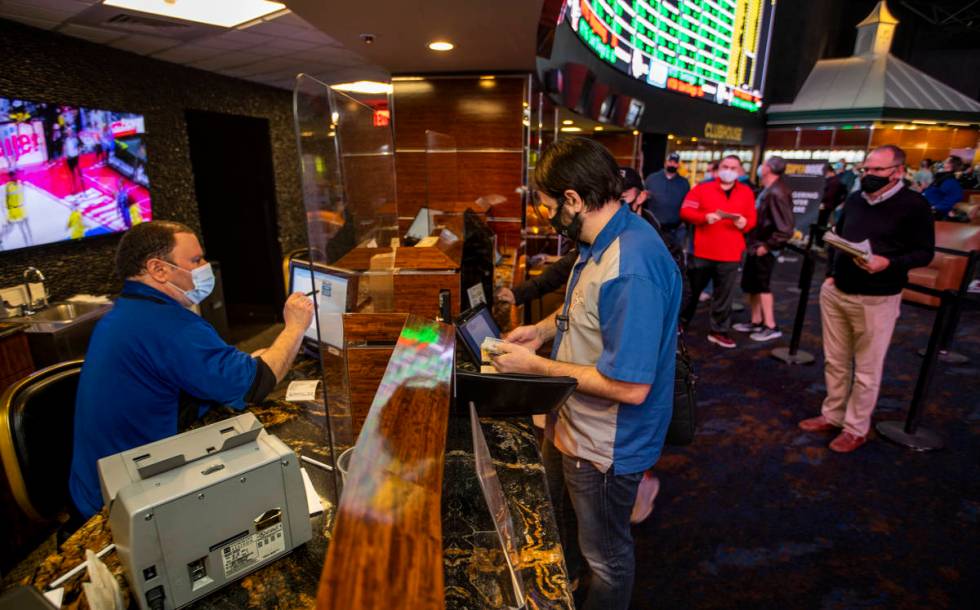 Mike Iannone, left, confers the bets placed by bettor Grayson Hart as the Westgate sportsbook p ...