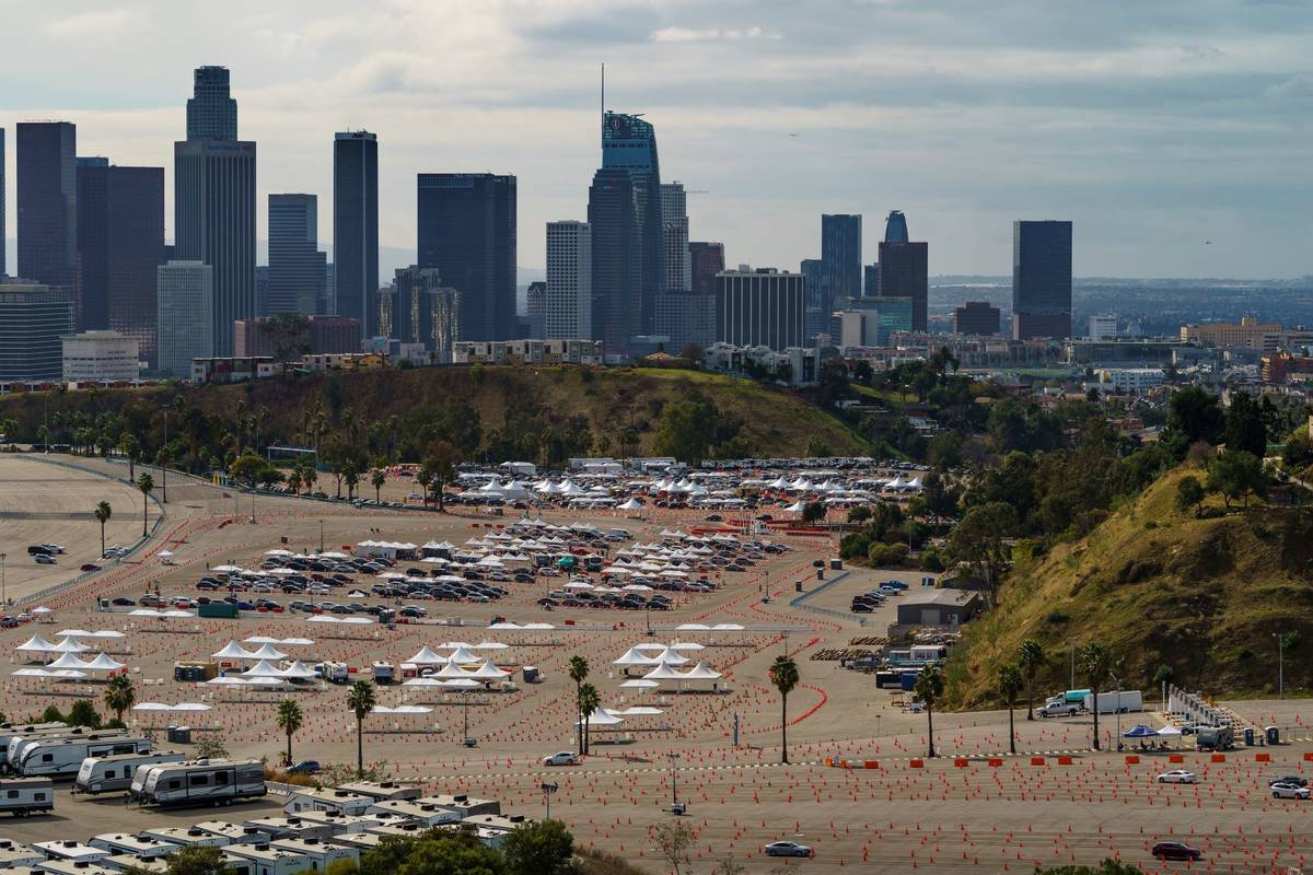 Drivers wait in line at a mega COVID-19 vaccination site set up in the parking lot of Dodger St ...