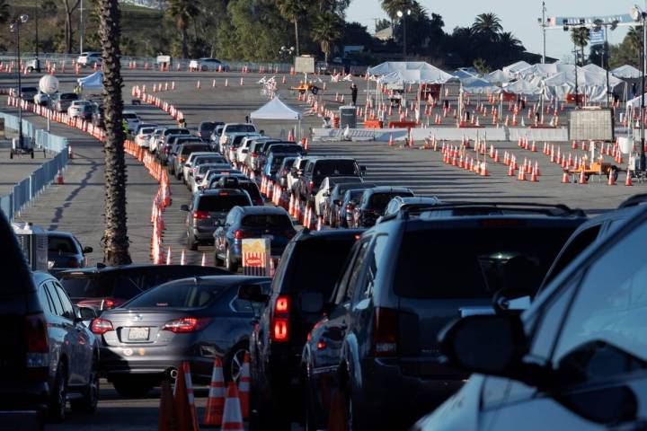 Los Angeles residents wait in line in their cars to receive a covid-19 vaccine at Dodger Stadiu ...