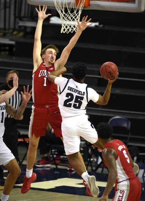 UNR's Grant Sherfield shoot against UNLV's Moses Wood in the first half of an NCAA college bask ...